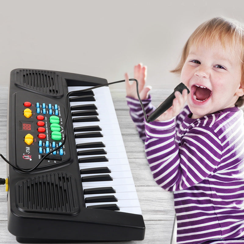Excited toddler singing into a microphone while playing a colorful keyboard, discovering their love for music.