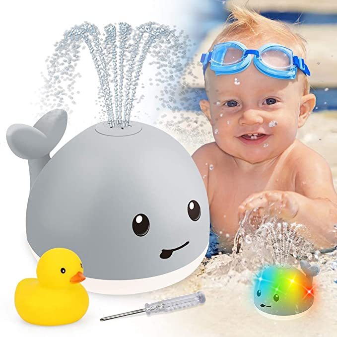 Baby playing with fun whale bath toy and rubber duck, creating splashes and colorful lights for an enjoyable bath time.