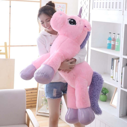 A child joyfully hugs a plush unicorn pillow soft toy, perfect for toddlers, babies, and children.